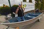 Robert Hayes kneels in the boat that he won during the Downtown Soup Kitchen's Slam'n Salm'n Derby after he caught a 40.97-pound king salmon June 15, 2008.